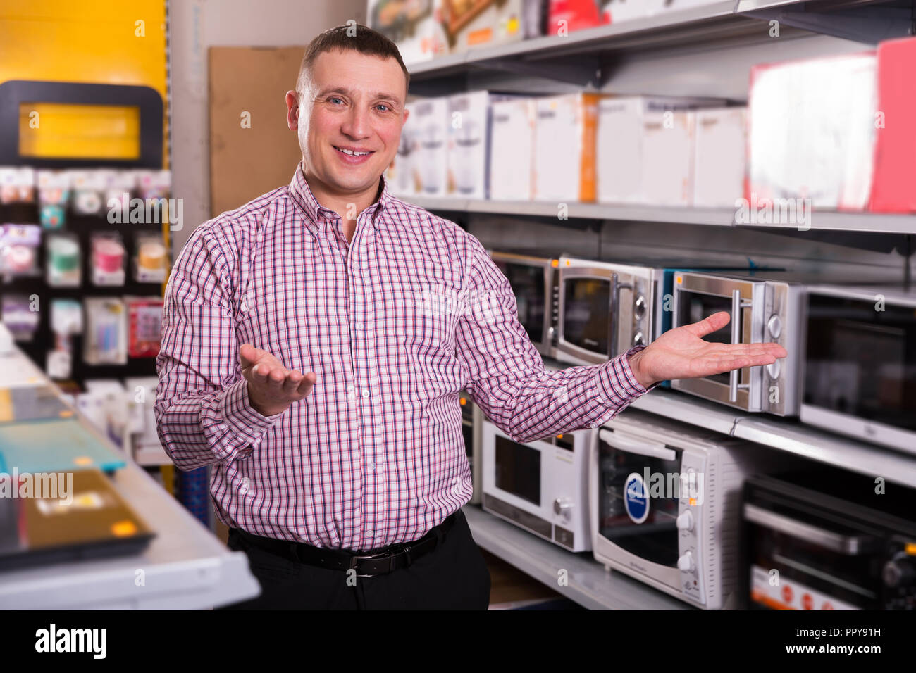 Middle-class  man choosing new microwave   in appliances store Stock Photo
