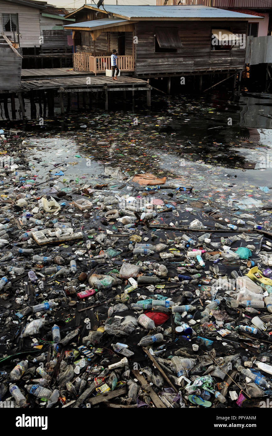 Plastic trash and other unsanitary pollution in ocean next to housing