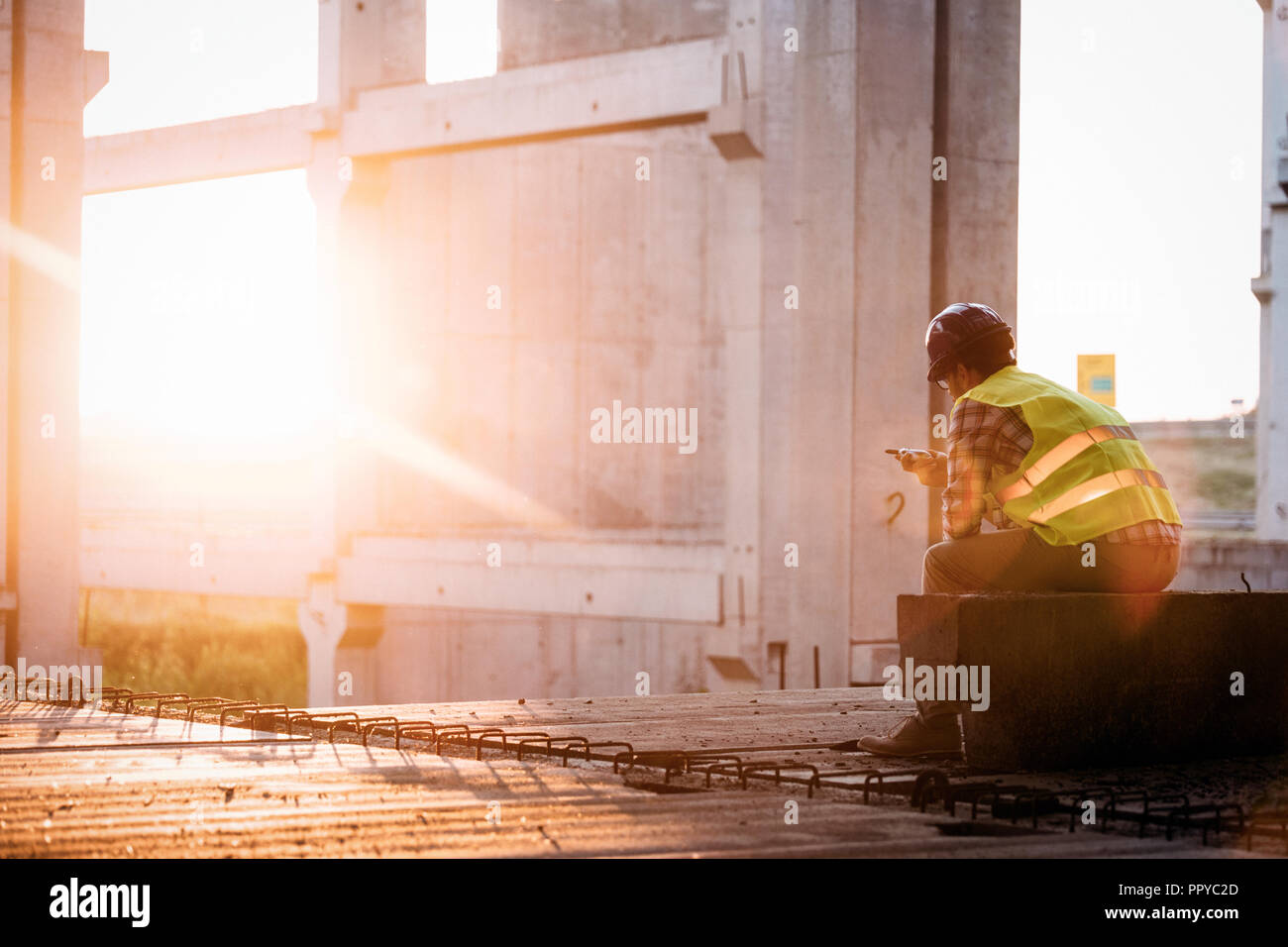 Male architect with blueprints using walkie-talkie Stock Photo