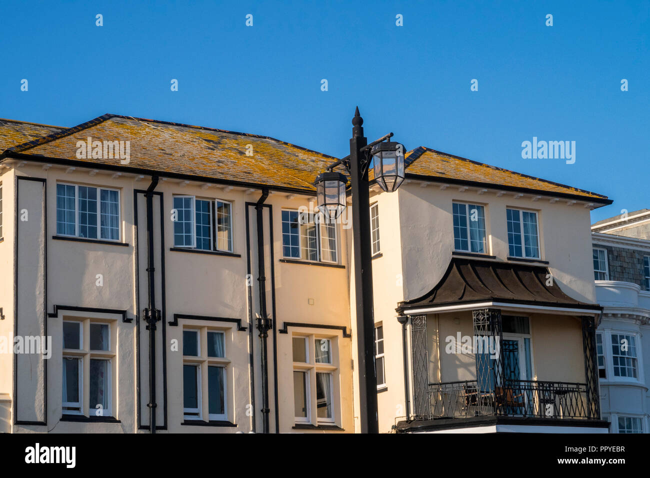 Yellow algae covering the roof of the Bedford Hotel in Sidmouth, contrasted by a bright blue sky. Stock Photo