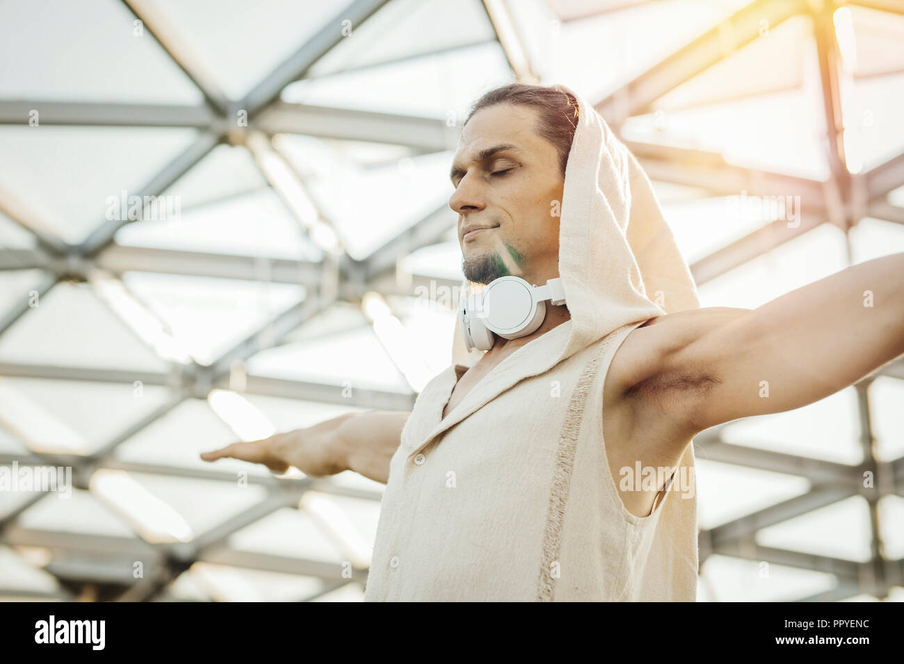 Close up of athletic man practicing yoga in modern park under the glass dome. Stock Photo