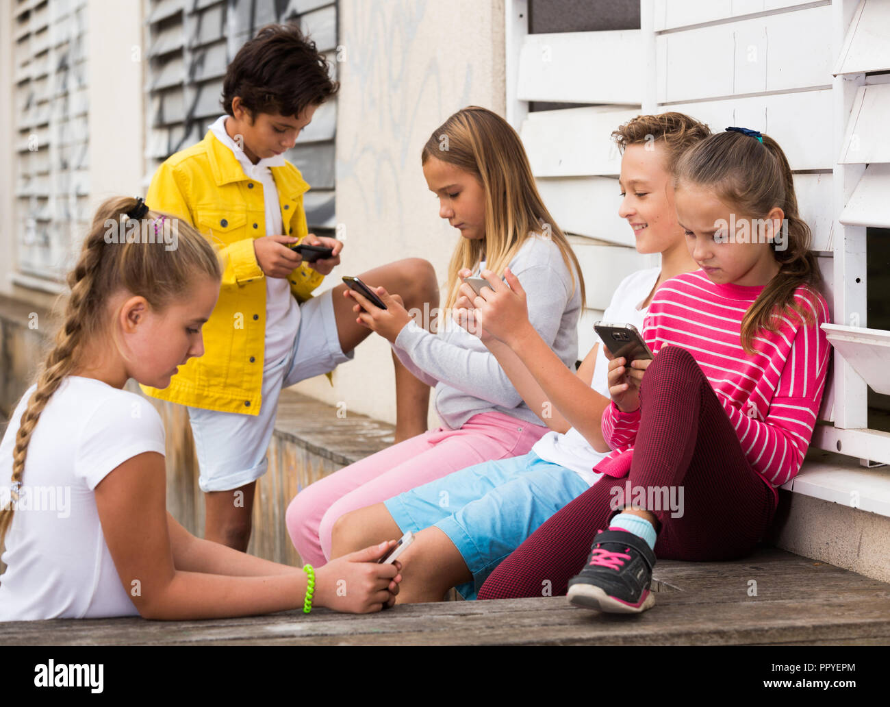 Cheerful children are chatting on their smartphone on walking Stock ...
