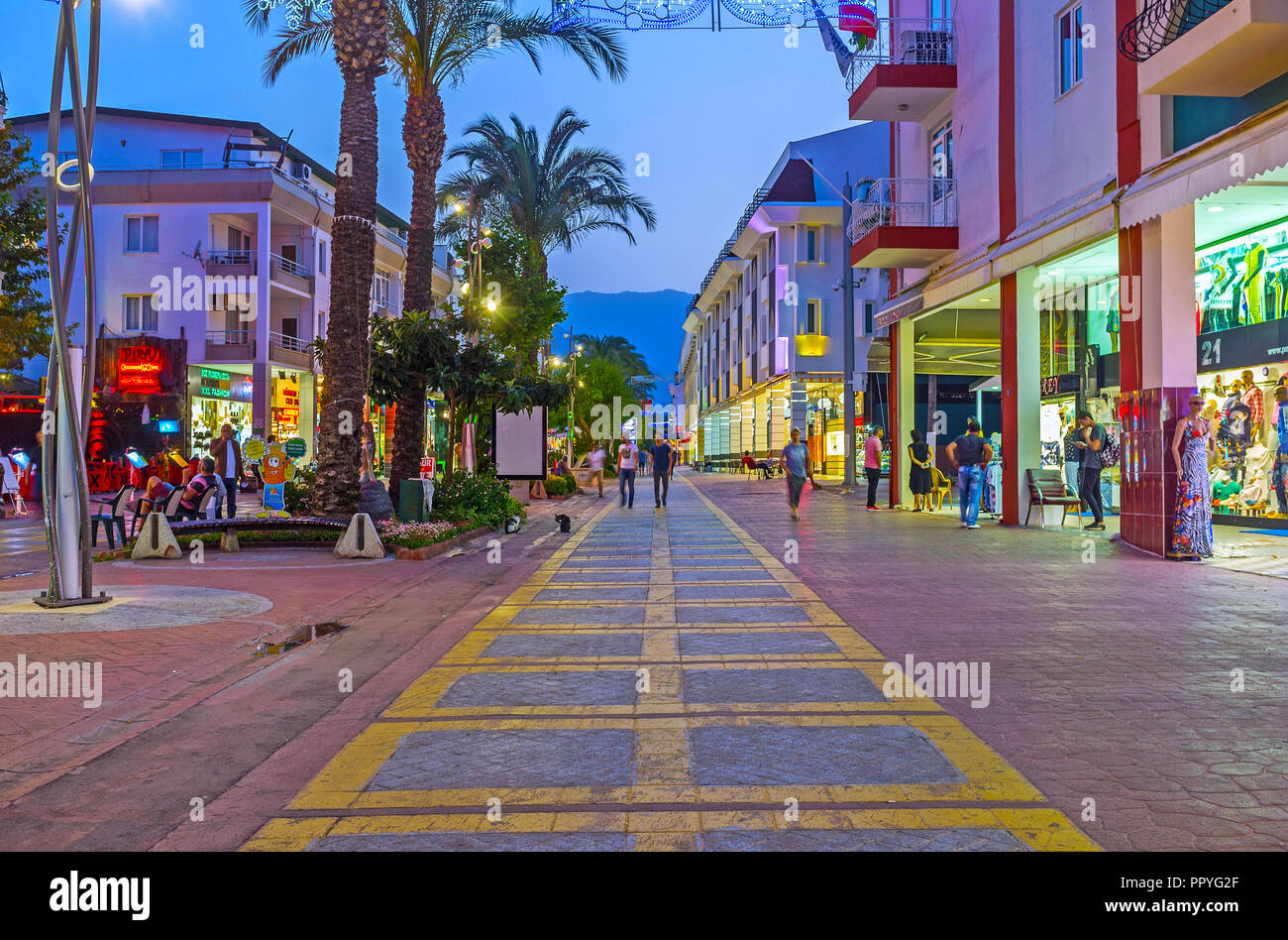 KEMER, TURKEY - MAY 13, 2017: The evening walk in the city center, the stores of the central shopping street attract the tourists with bright lights,  Stock Photo