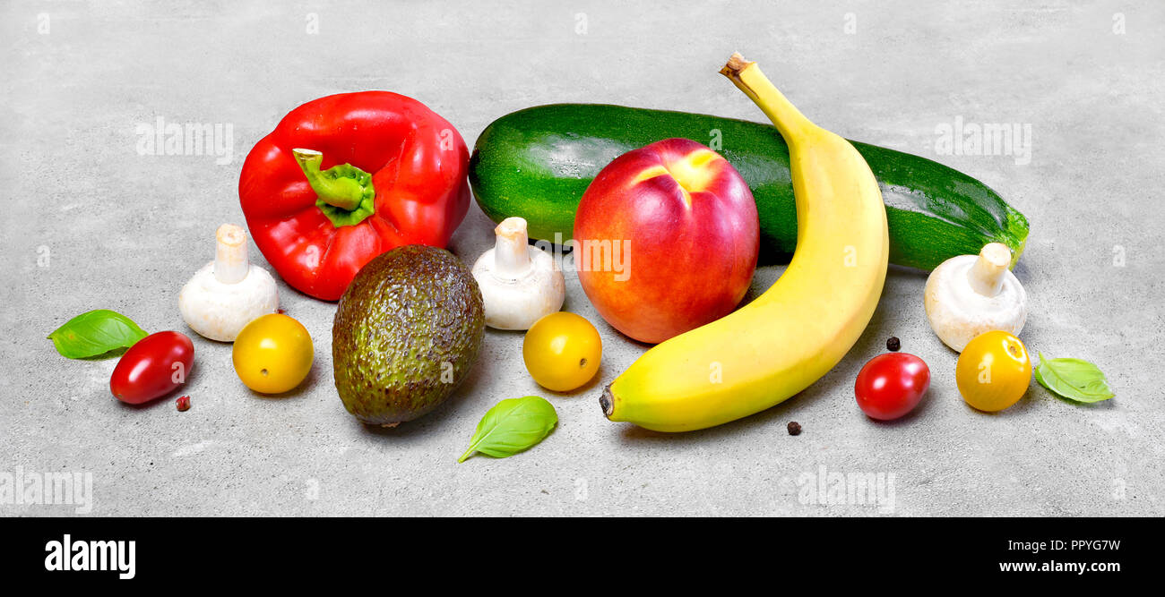 Delicious fresh fruits and vegetables on a stone background. Top view with copy space. Delicious food background. Stock Photo
