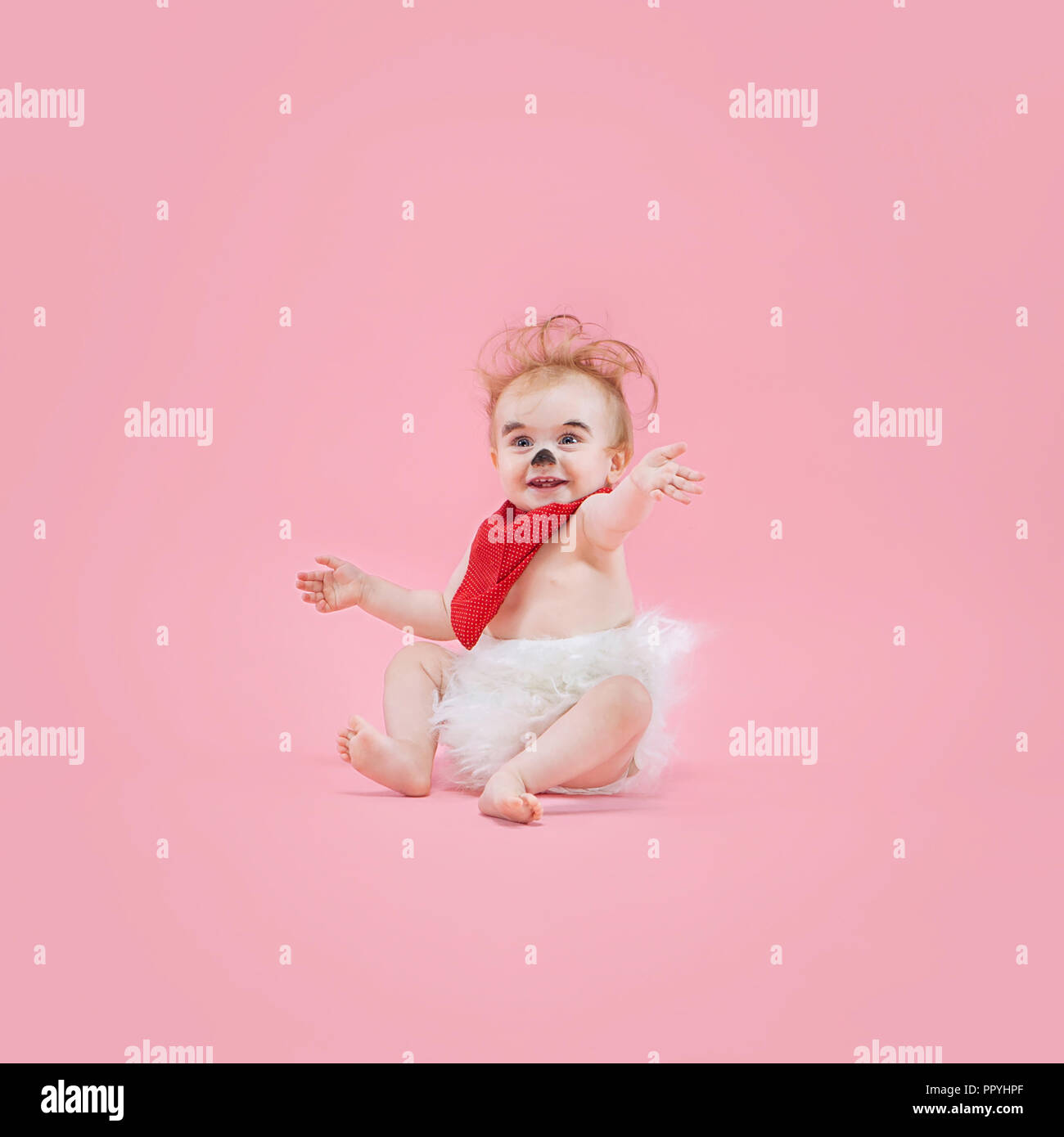 Newborn baby girl wearing a Halloween costume on pink studio background Stock Photo