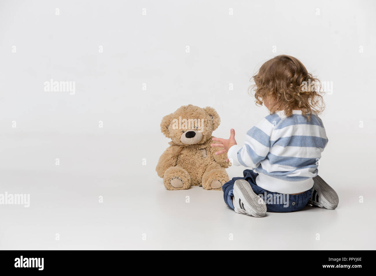 Portrait of happy joyful beautiful little boy playing with teddy bear ...