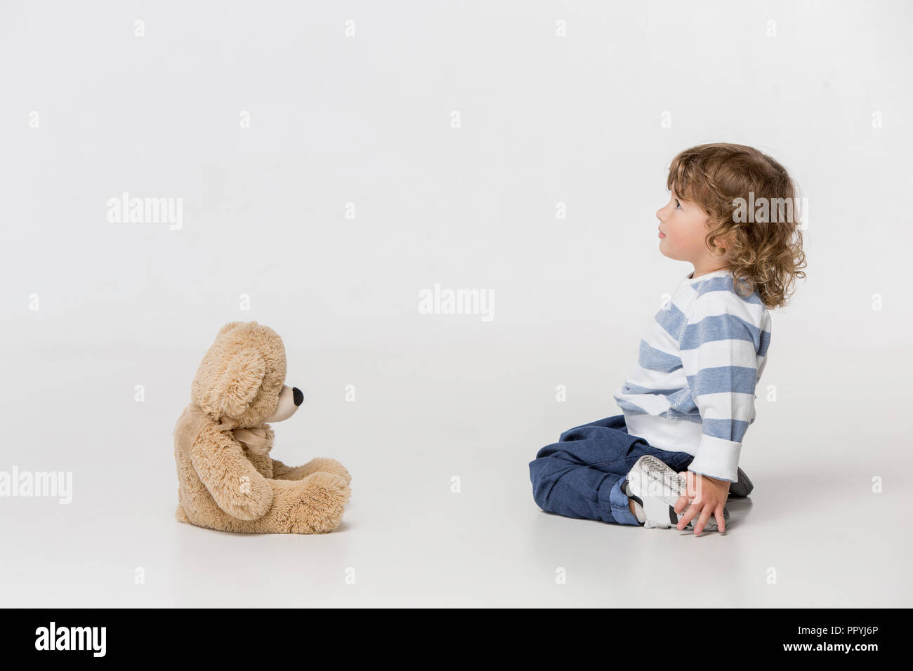 Portrait of happy joyful beautiful little boy playing with teddy bear ...