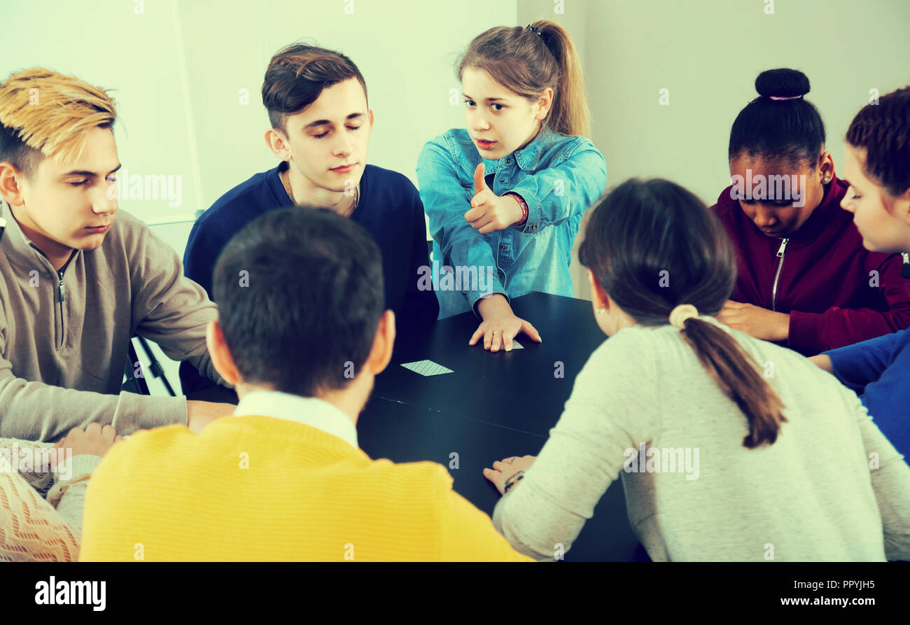positive spanish classmates having round of Werewolf game at break ...