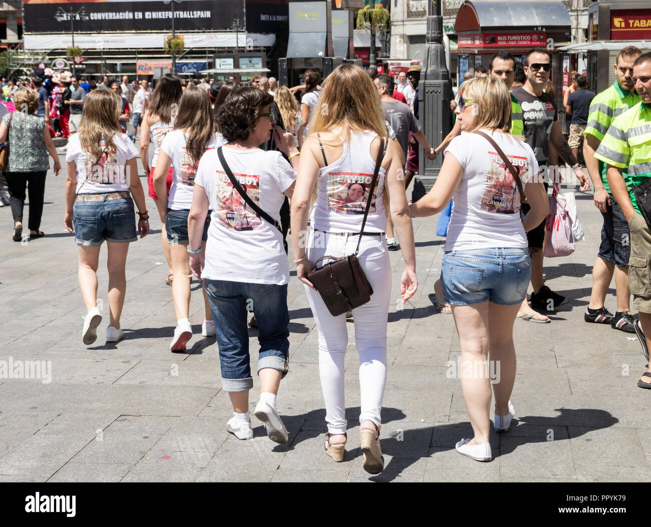 Workmen staring at women on Hen party in Madrid. Women wearing Playboy shirts. Madrid Spain Stock Photo
