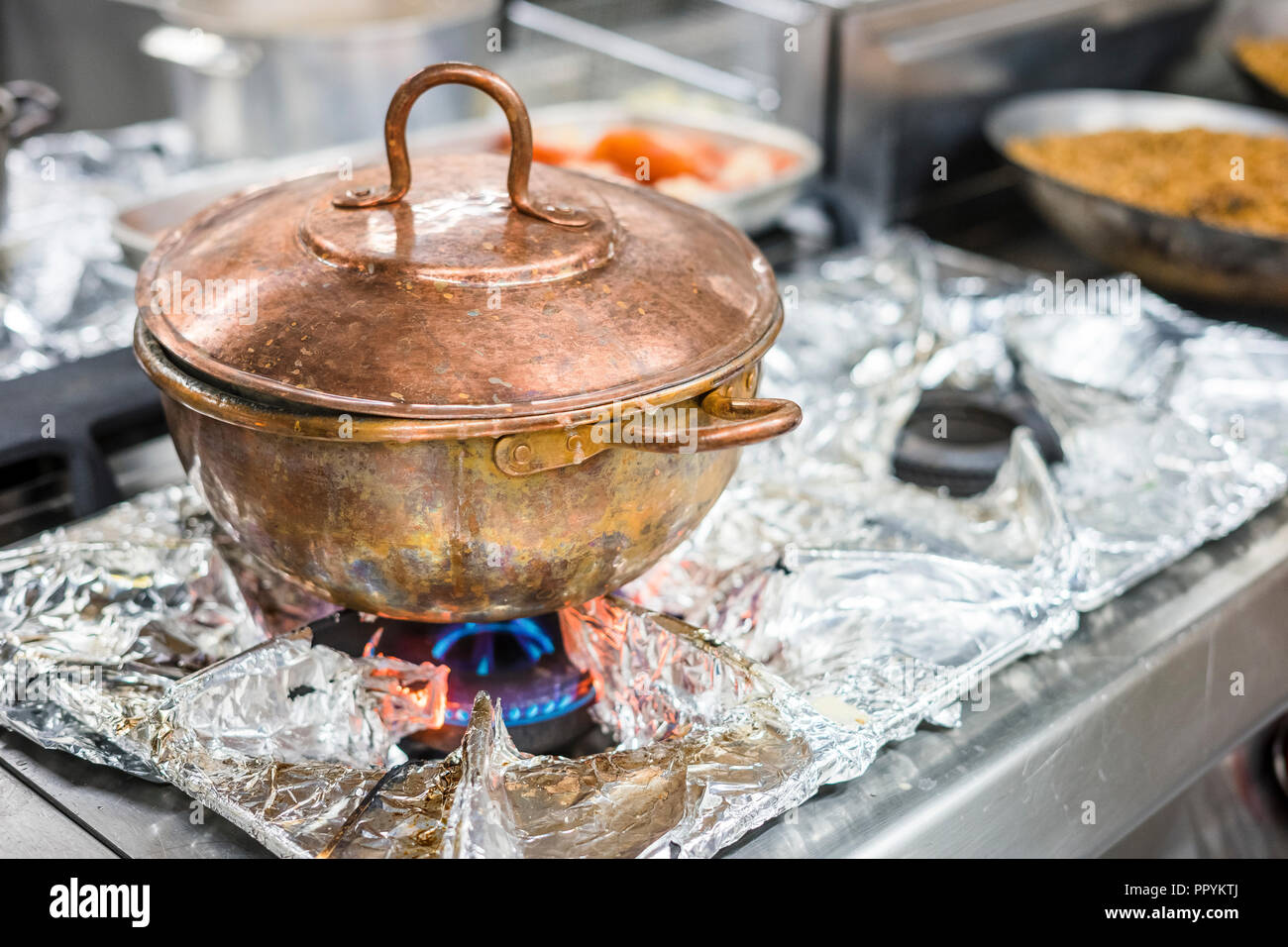 https://c8.alamy.com/comp/PPYKTJ/vintage-copper-pot-with-food-on-gas-stove-in-the-restaurant-PPYKTJ.jpg