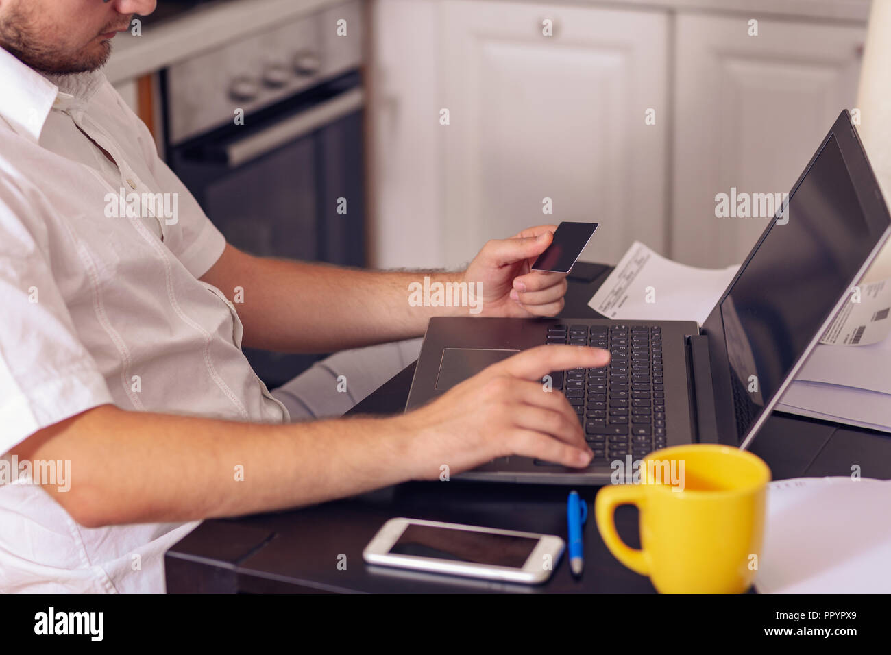 Young freelancer working from home and paying bills Stock Photo