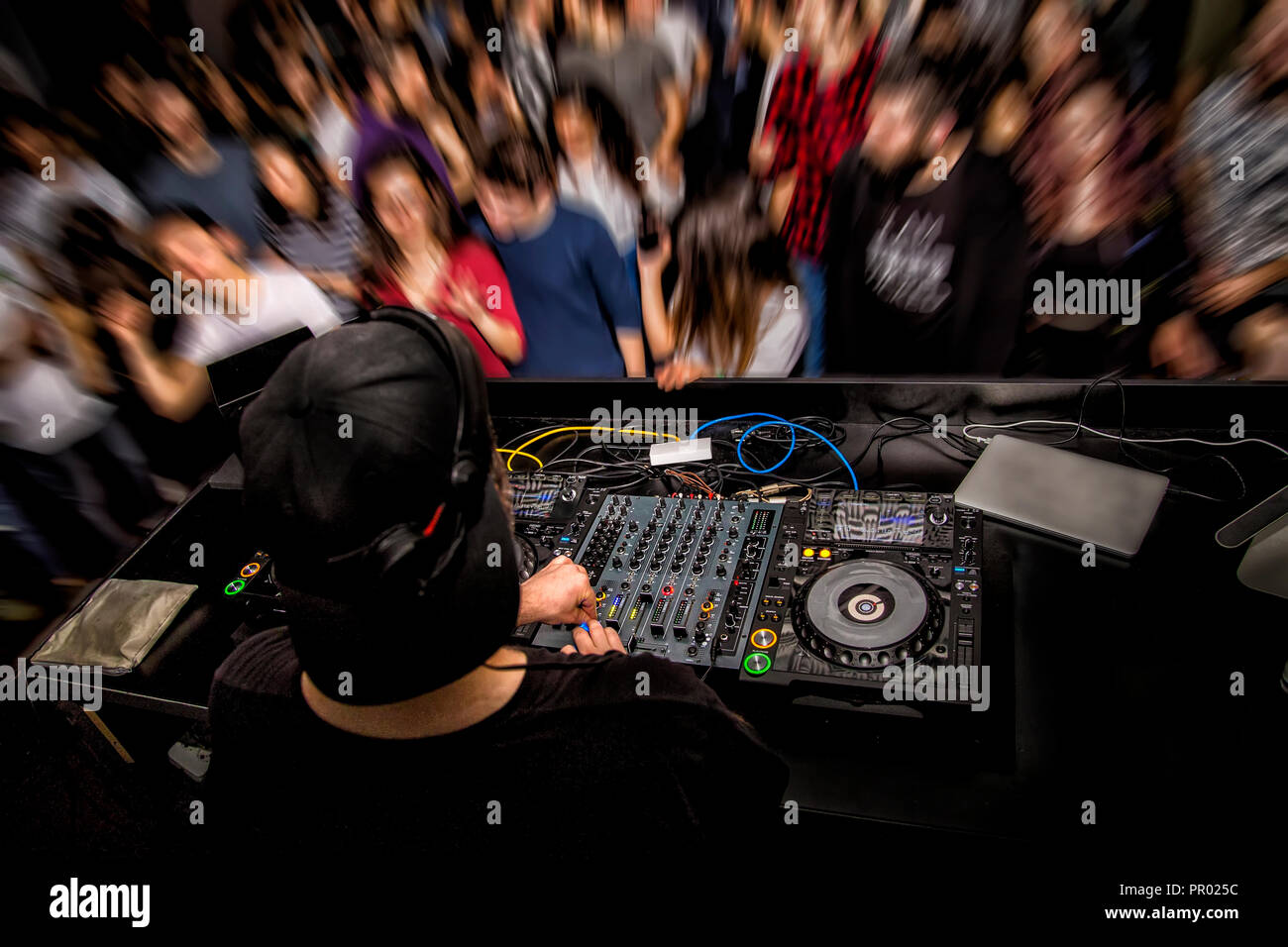 DJ with dj set at night club party. People at the party are having fun on  the background Stock Photo - Alamy