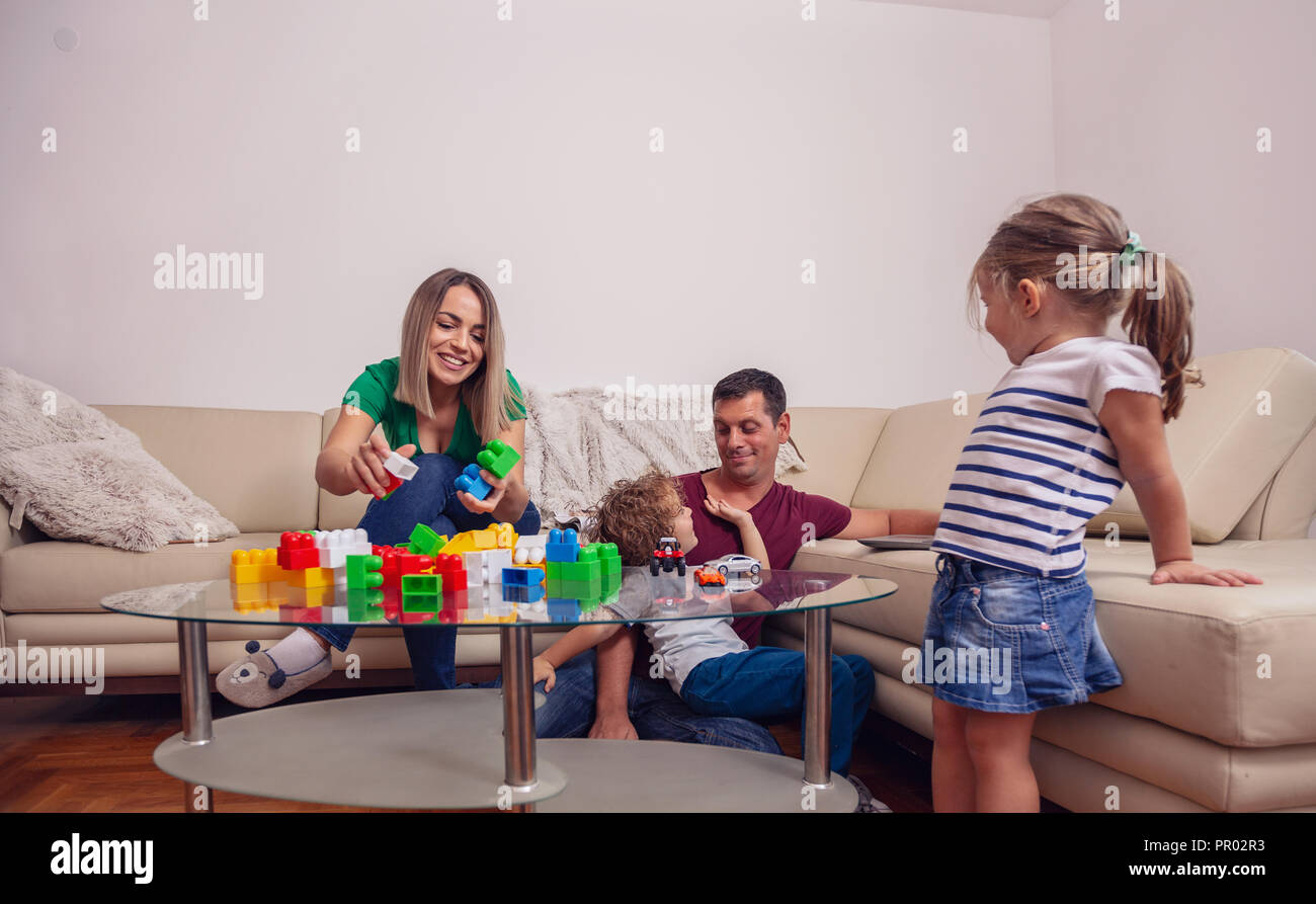 Family time - Young father using a laptop computer for work at home while looking after his son Stock Photo