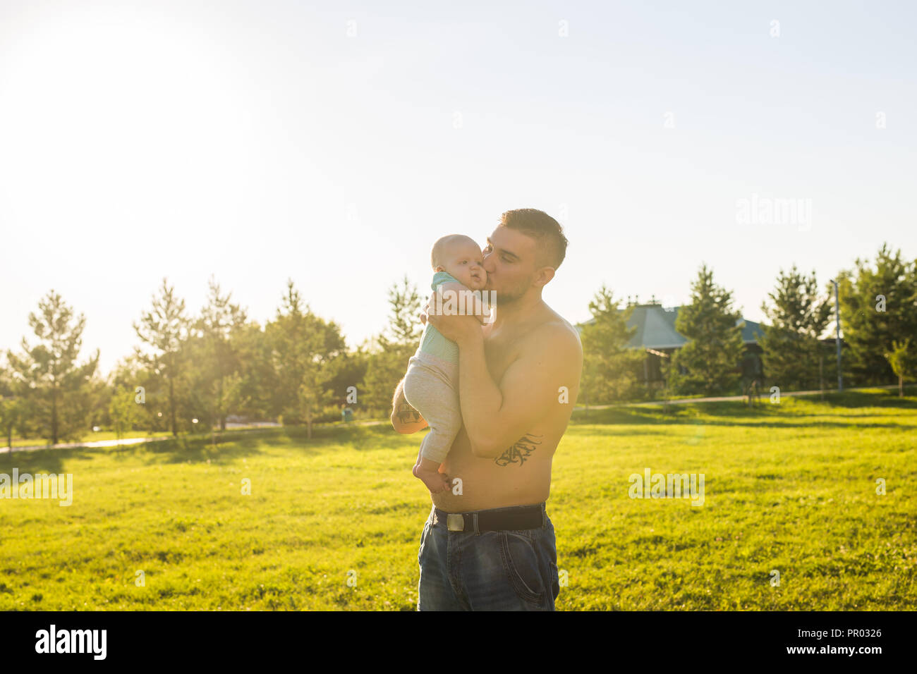 Happy father holding baby son, throwing baby in air. Concept of happy
