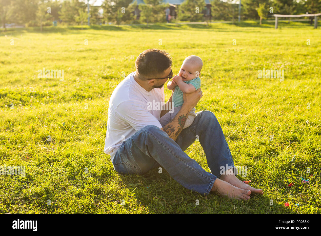 Happy father holding baby son, throwing baby in air. Concept of happy
