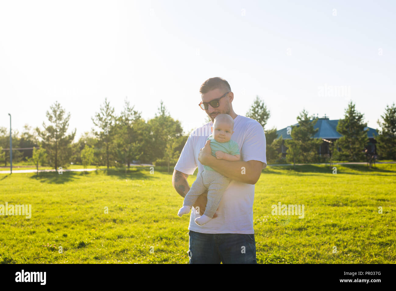 Happy father holding baby son, throwing baby in air. Concept of happy