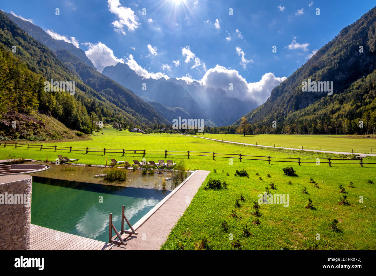 Panoramic view Logarska valley, Slovenia with pond and sunchairs in front Stock Photo