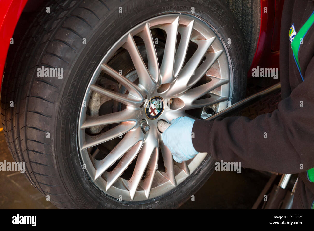 Tyre fitter / mechanic tightens / tightening / checking the nuts with a
