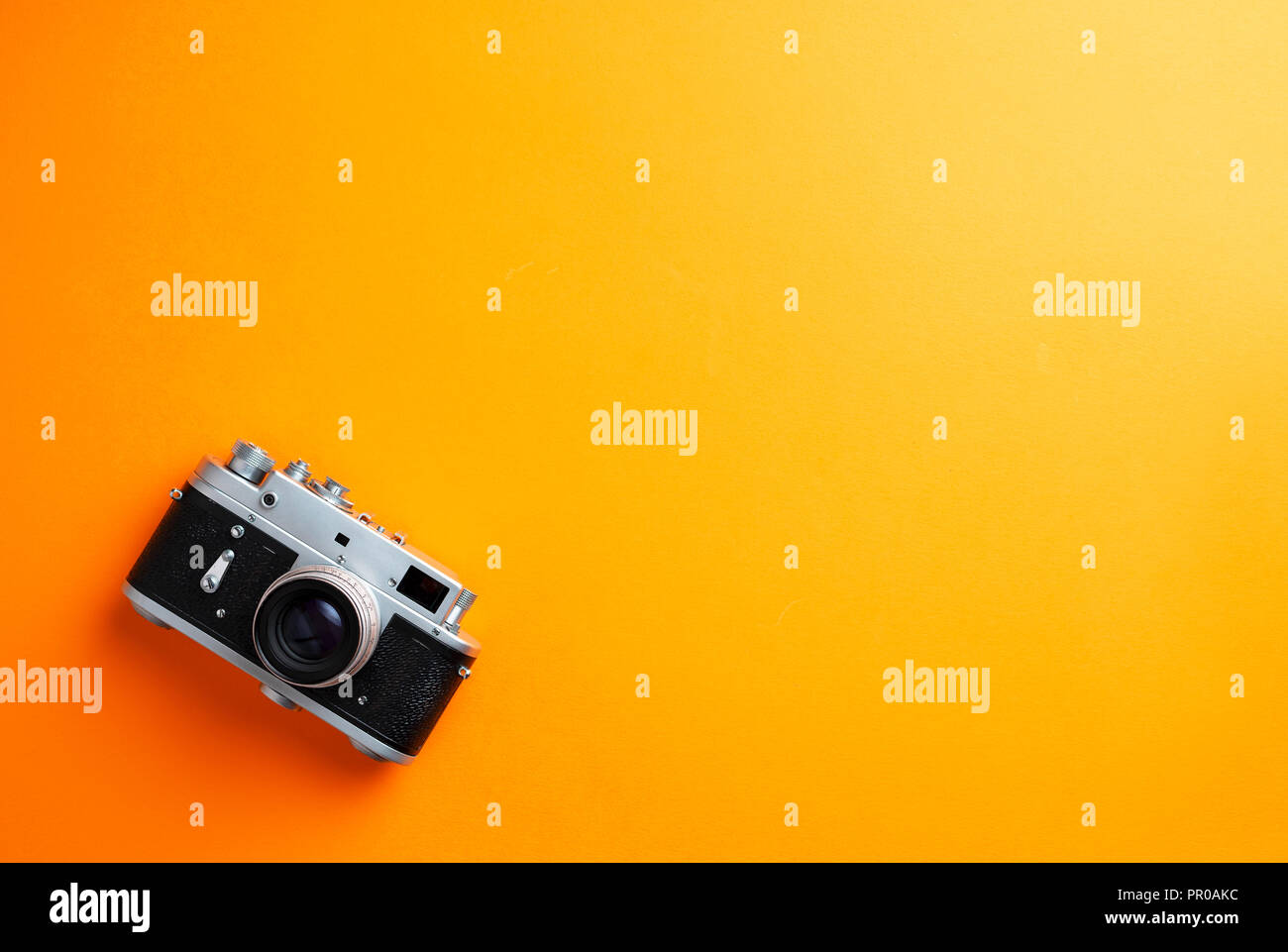 Vintage camera over orange background with negative space Stock Photo