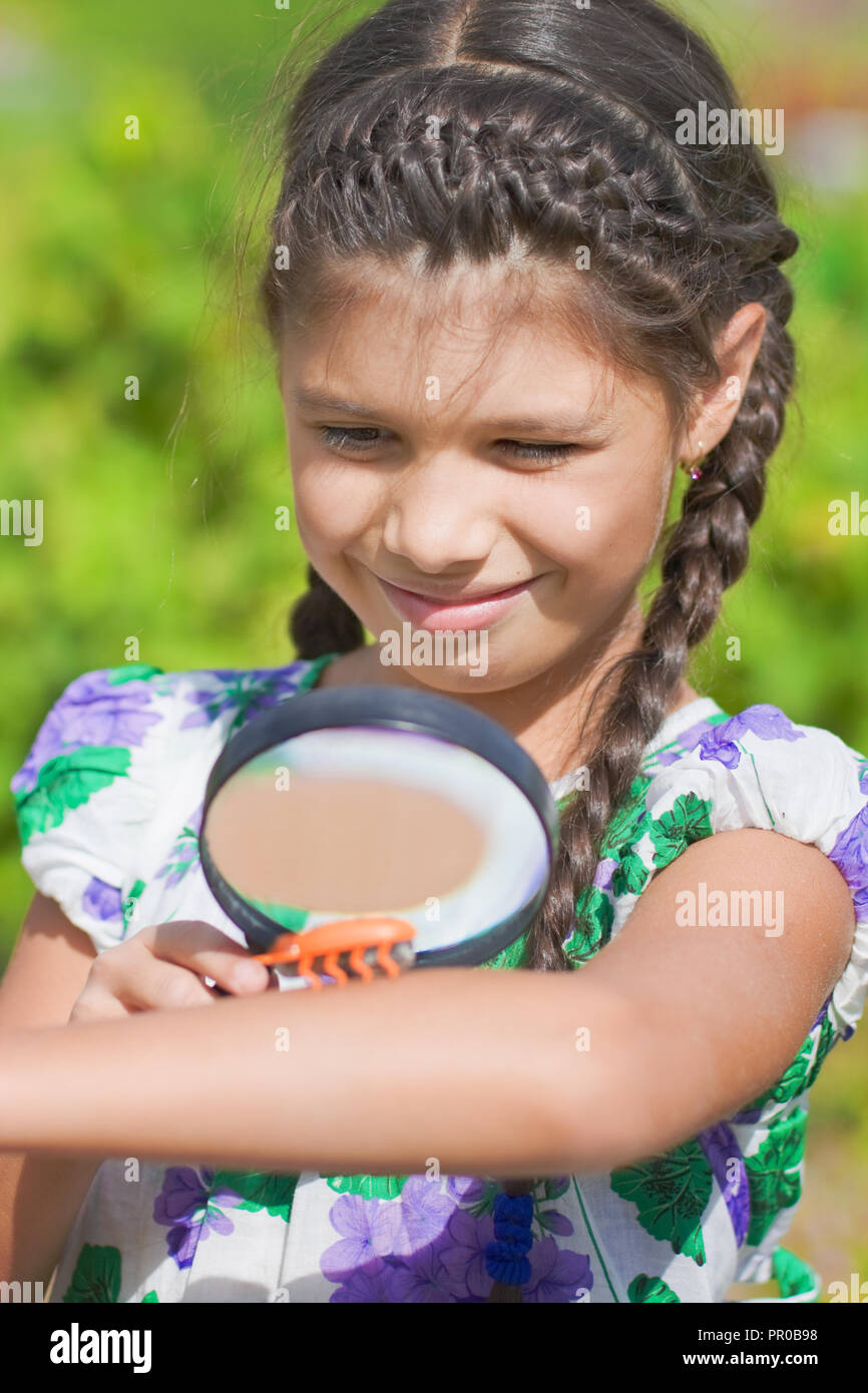 Suprised girl look at beetle on your hand through magnifying glass Stock Photo