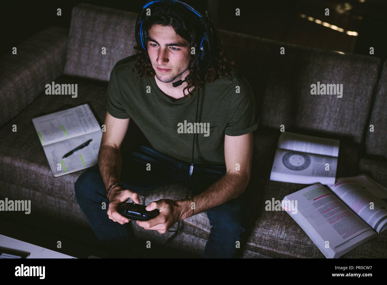 Young Man Playing Video Game Using Joystick And Headphones