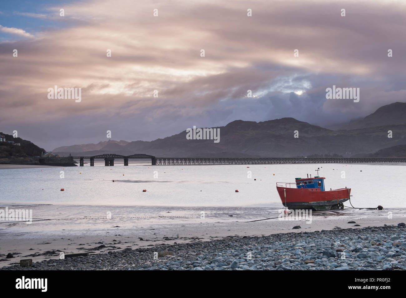 Fishing boat and Barmouth Bridge in Barmouth Harbour with Cader (Cadair) Mountains behind, Snowdonia National Park, North Wales, Wales, United Kingdom Stock Photo