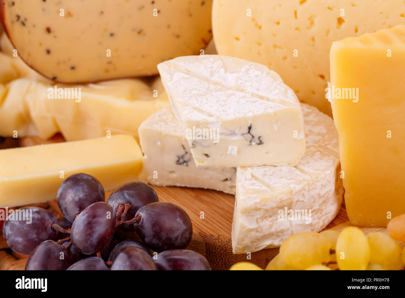 Various type of cheese and grapes closeup picture. Stock Photo