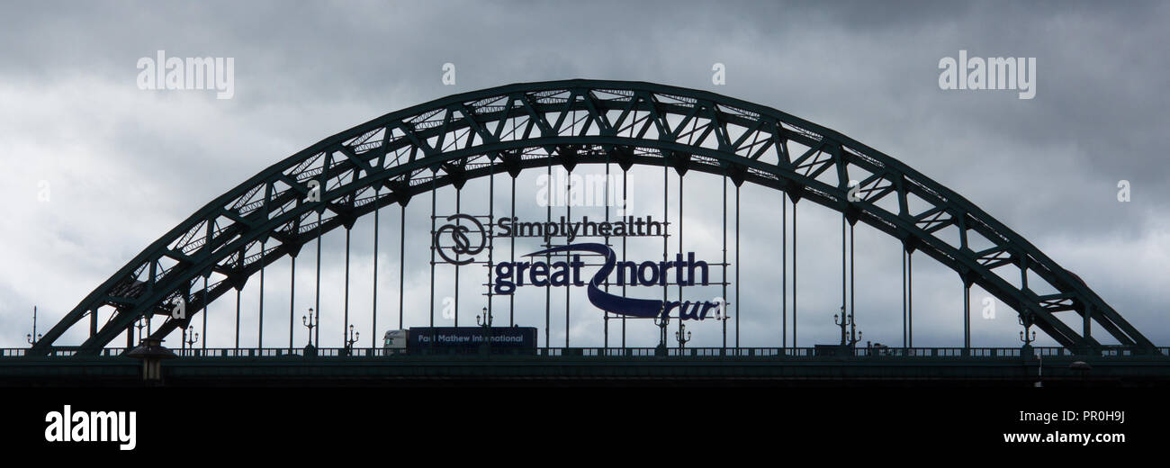 The Tyne bridge over the river Tyne Newcastle upon tyne in silhouette with advertisement for the great north run Stock Photo