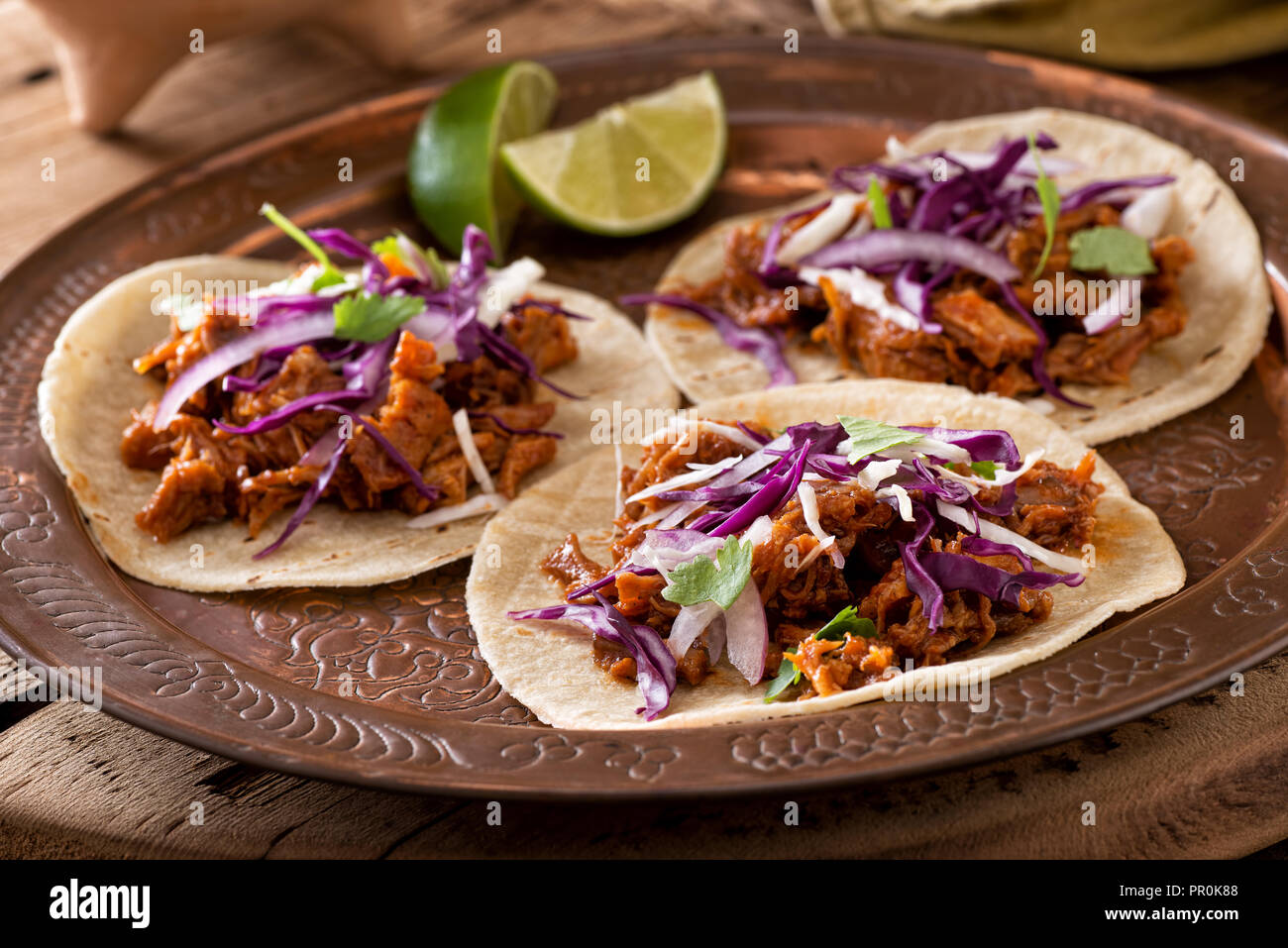 Three delicious pulled pork tacos with cabbage, onion and cilantro. Stock Photo