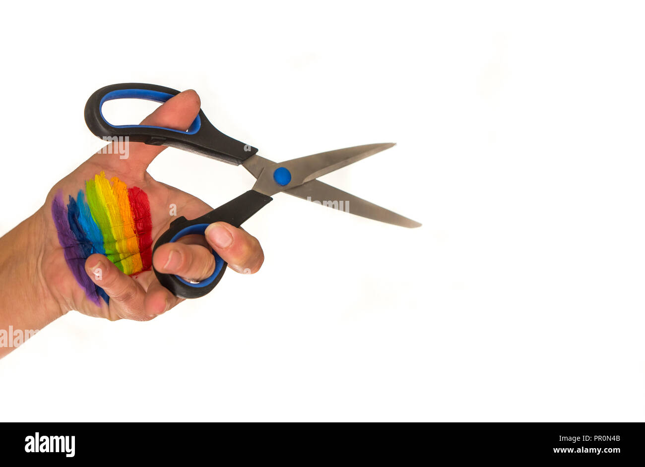 white background, at the back a blurred image of a woman with blonde hair, on the front hand holding scissors cutting the air. The hand painted in rai Stock Photo