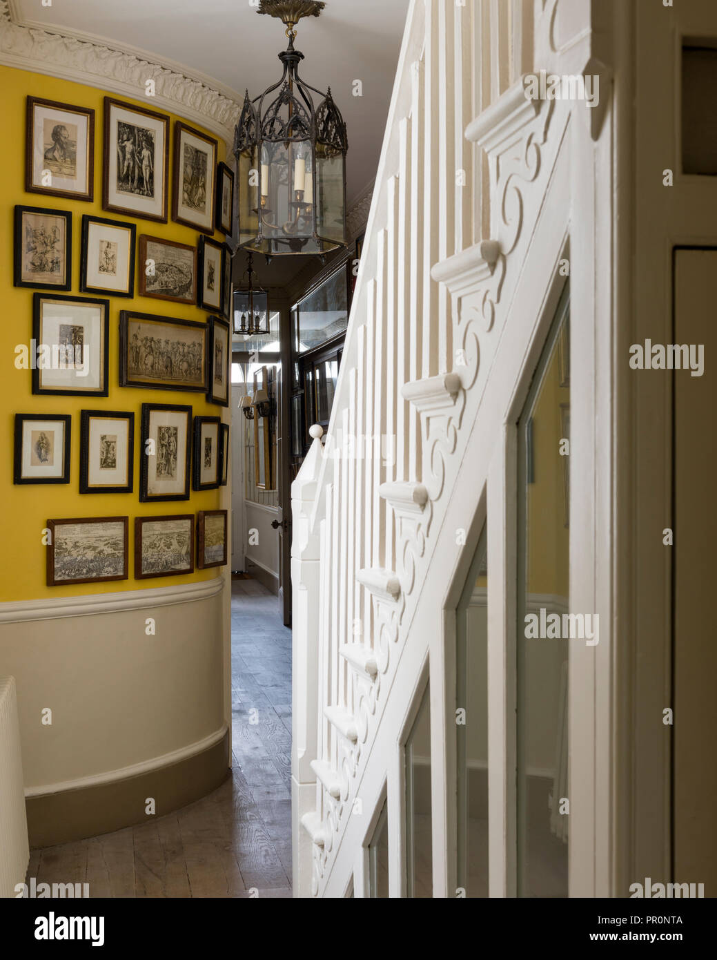 Curved picture wall in entrance hallway with vintage glass lantern Stock Photo