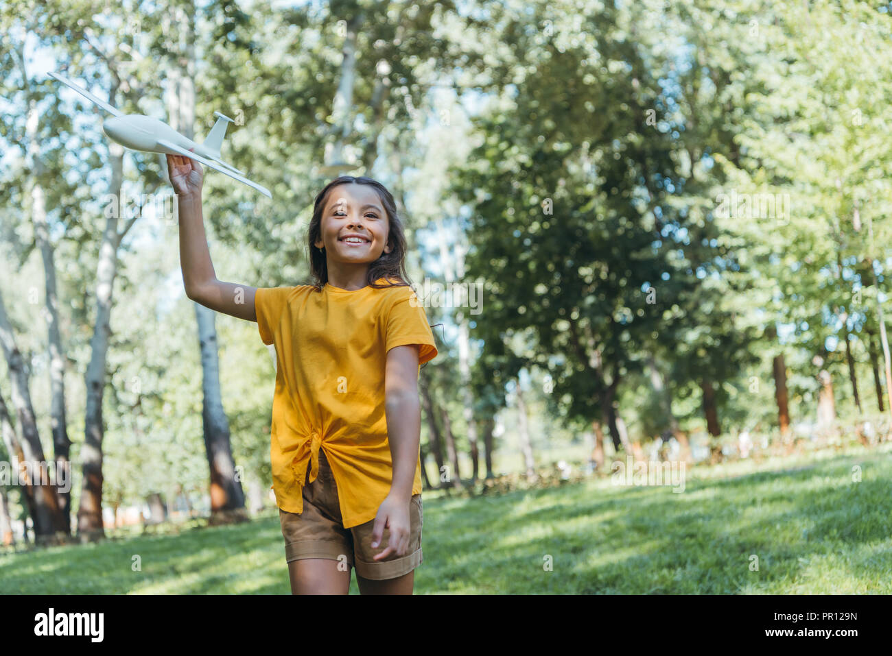 adorable happy child playing with toy plane in park Stock Photo