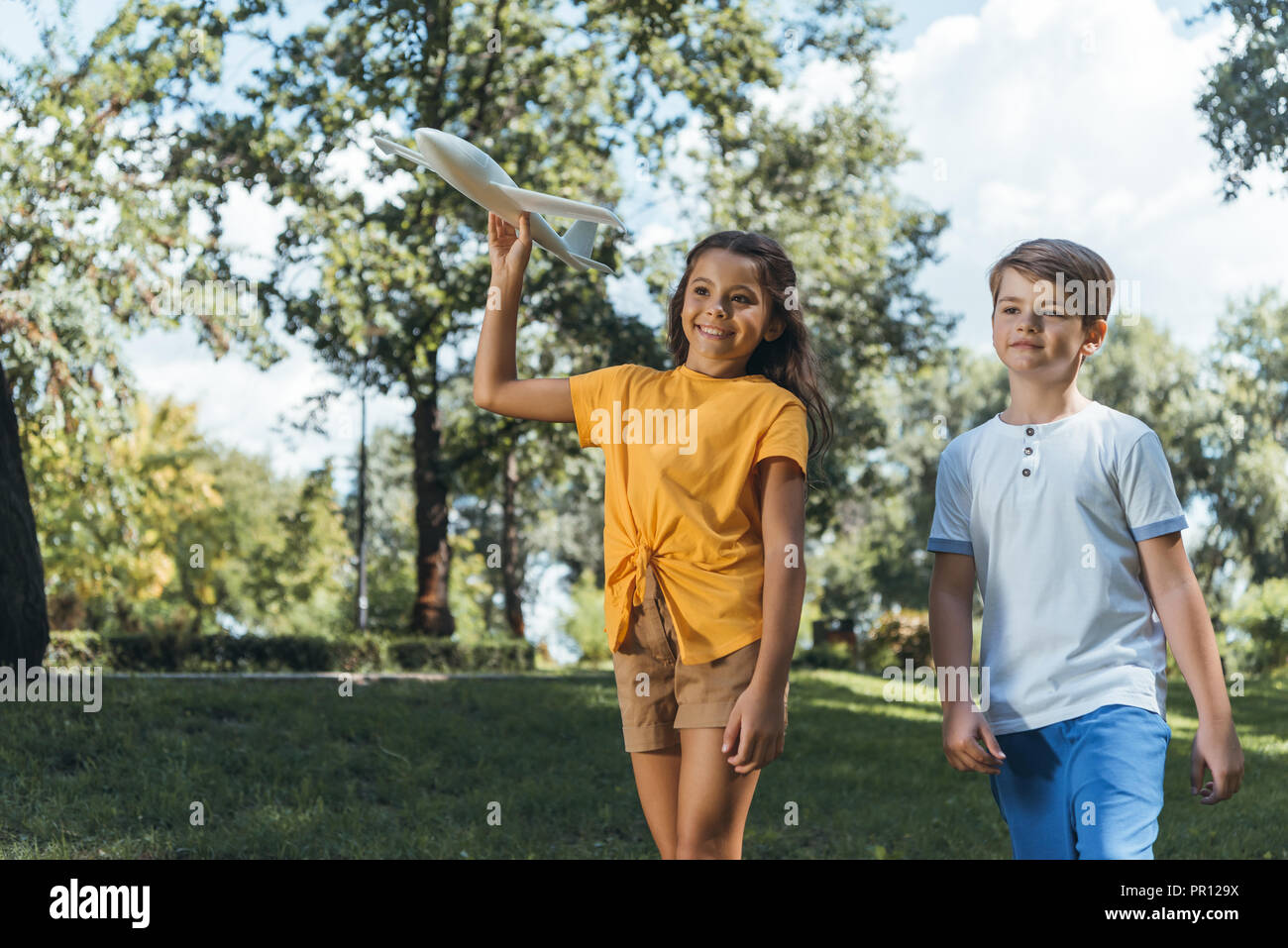 cute smiling children playing with plane model in park Stock Photo - Alamy
