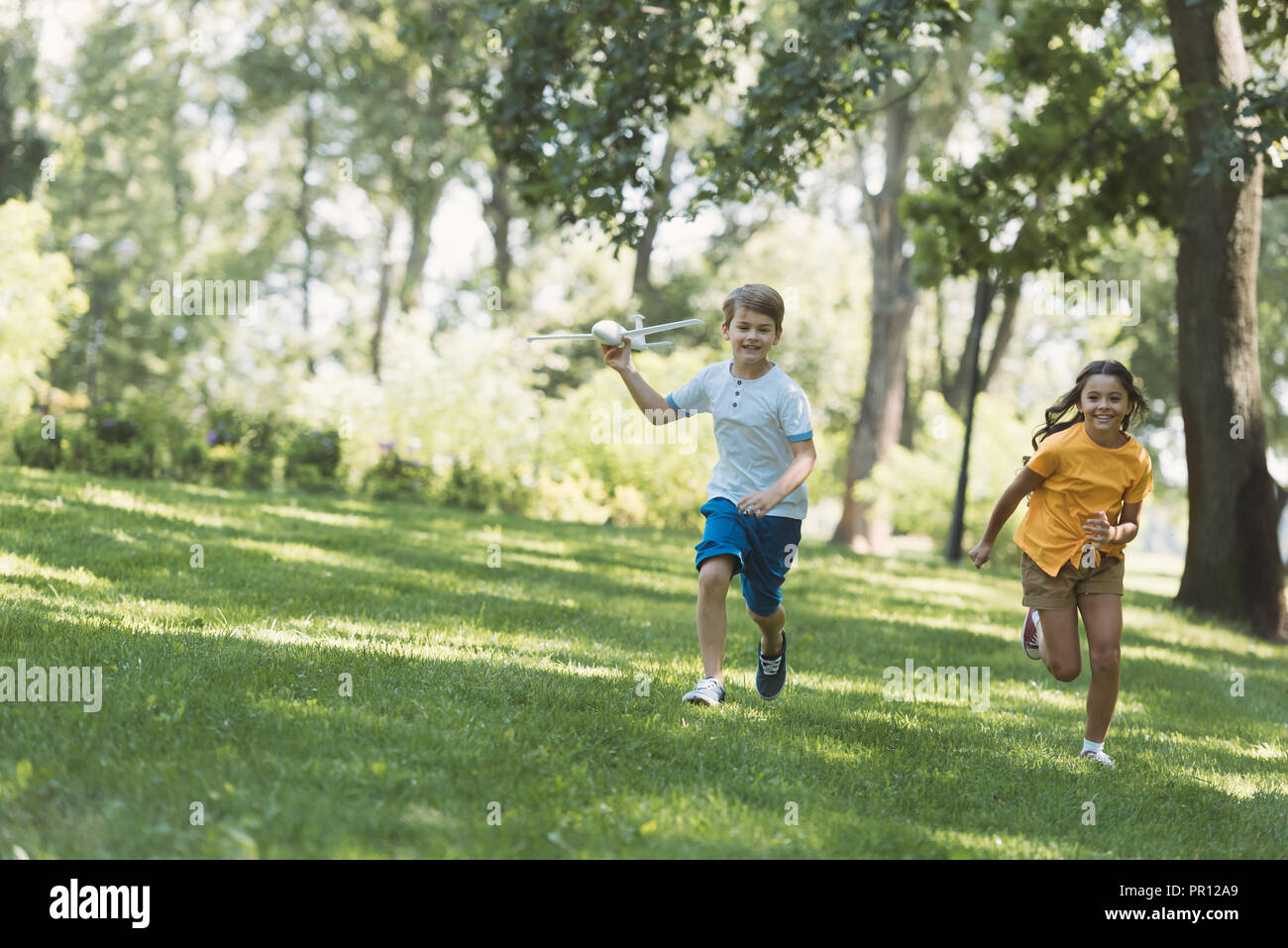 cute happy children playing with plane model and running in park Stock ...
