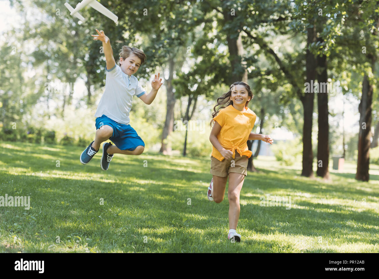adorable happy children playing with plane model in park Stock Photo ...