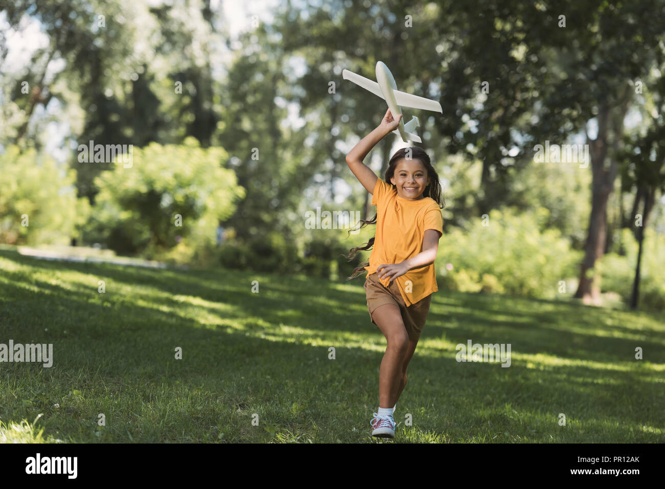 cute happy child throwing toy plane in park Stock Photo