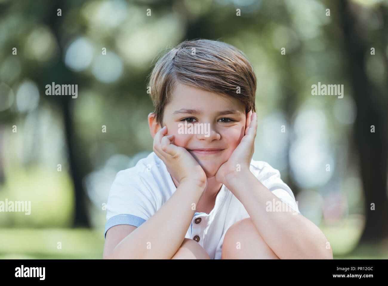 portrait of cute happy little boy smiling at camera in park Stock Photo ...