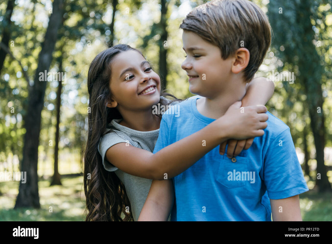 cute happy children hugging and smiling in park Stock Photo - Alamy