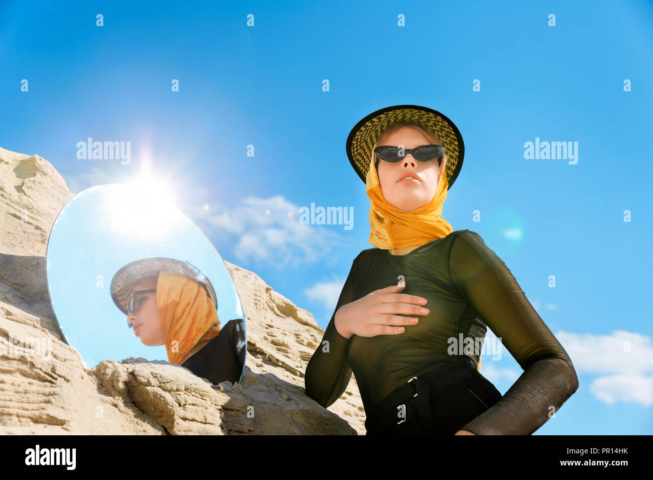 stylish beautiful young woman posing with mirror and sunflare Stock Photo