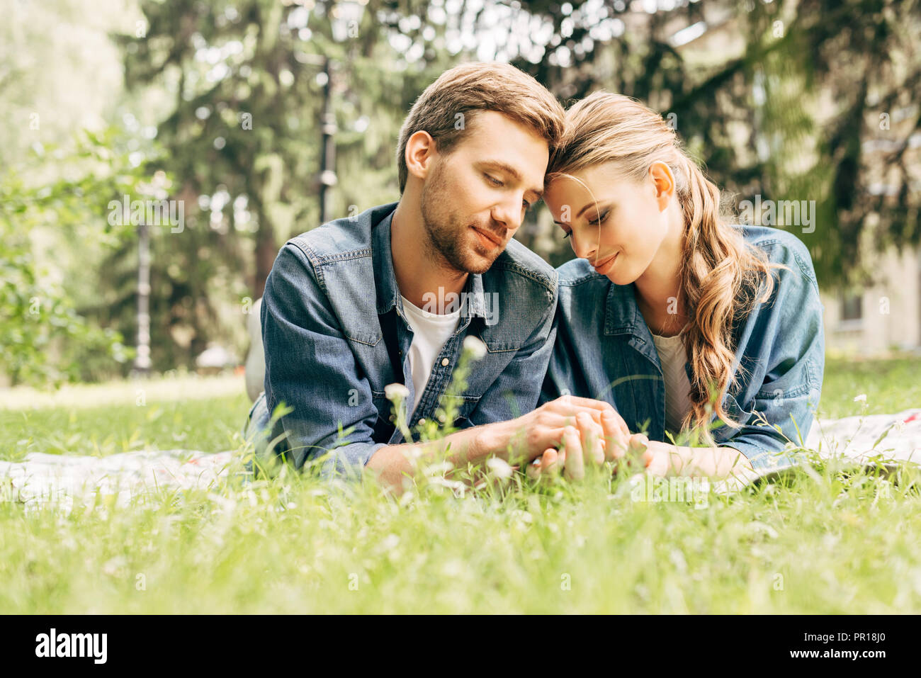 Young couple lying on grass hi-res stock photography and images - Alamy