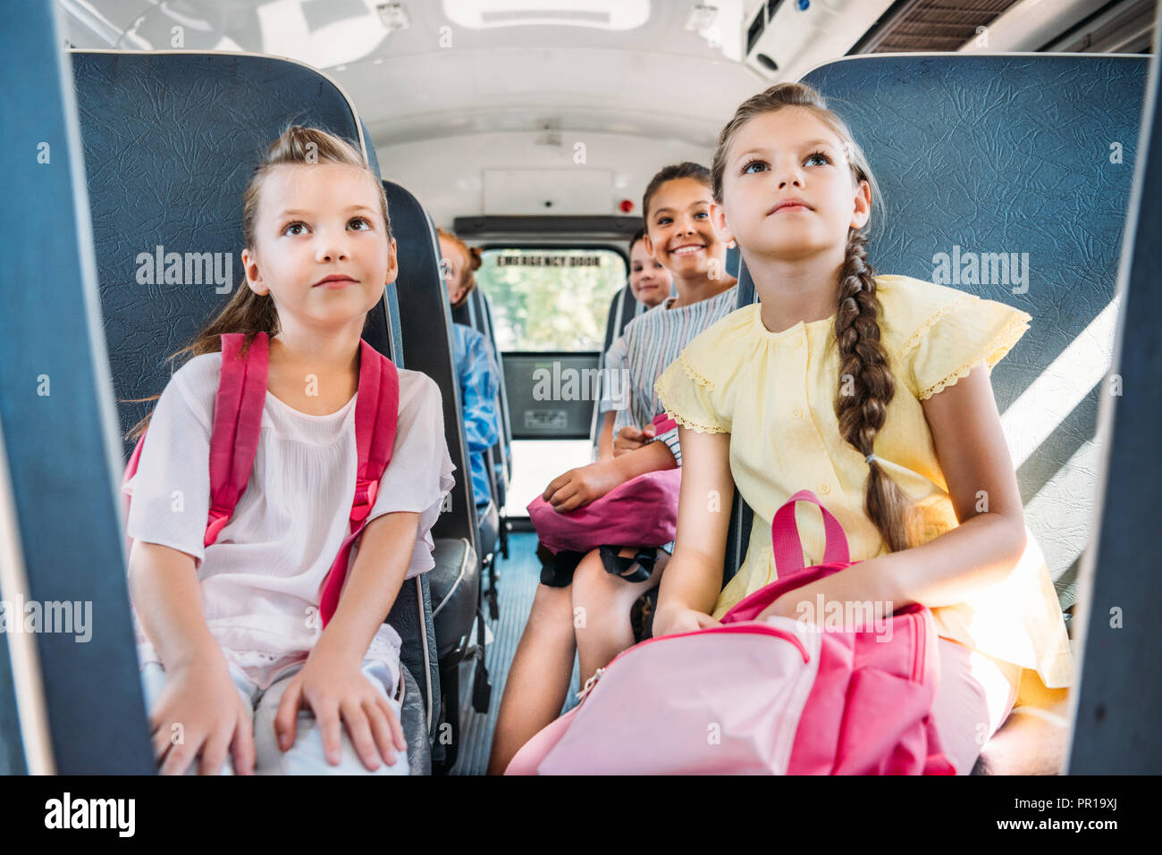 group of pupils riding on school bus during school excursion and ...