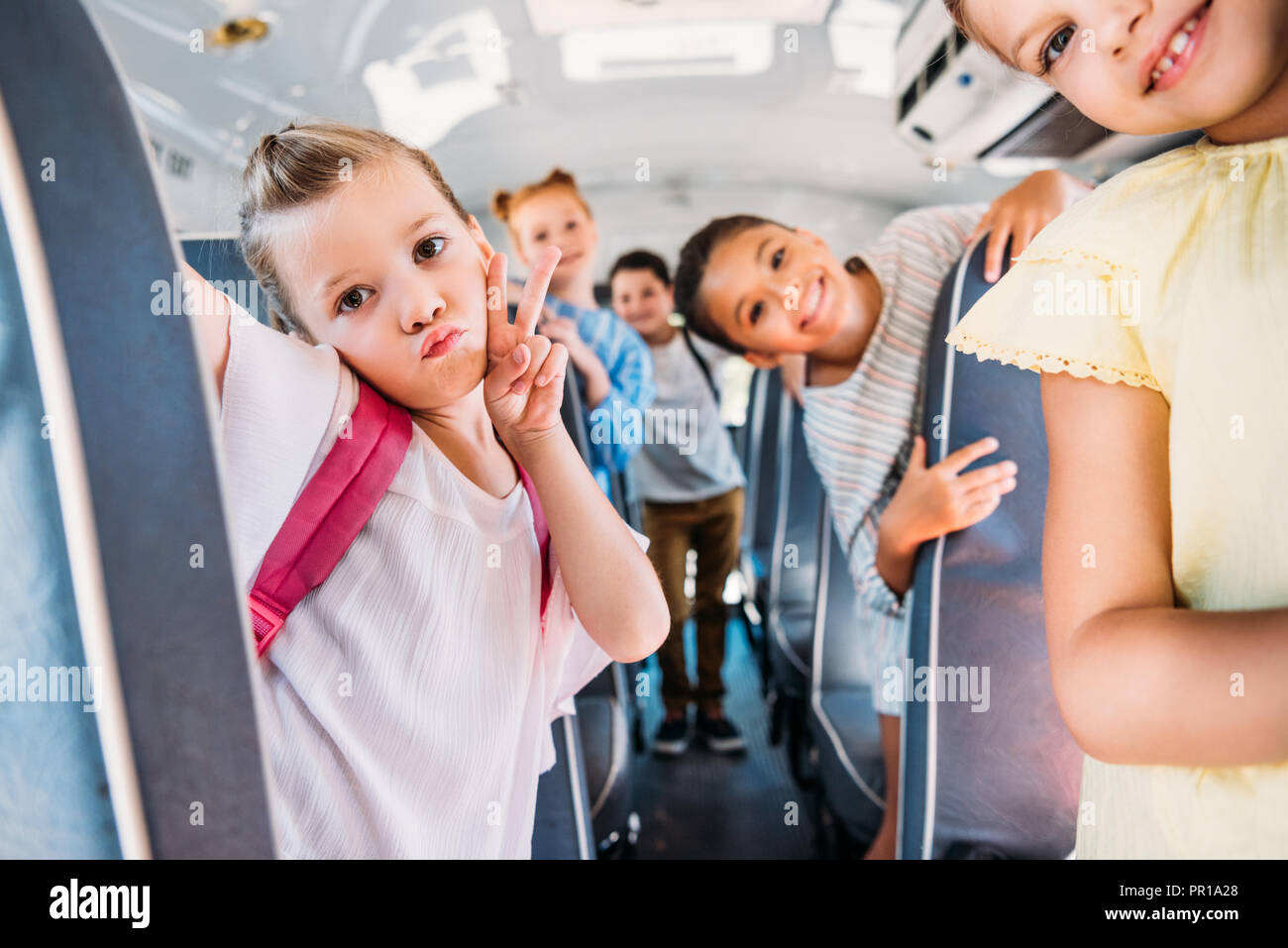 Kids Riding Bus group of happy schoolchildren riding on school bus and looking at ...