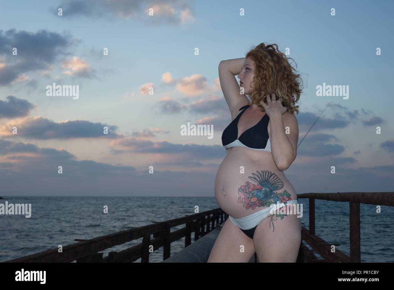 amazing pregnancy woman with tattooing, in coast sea Stock Photo