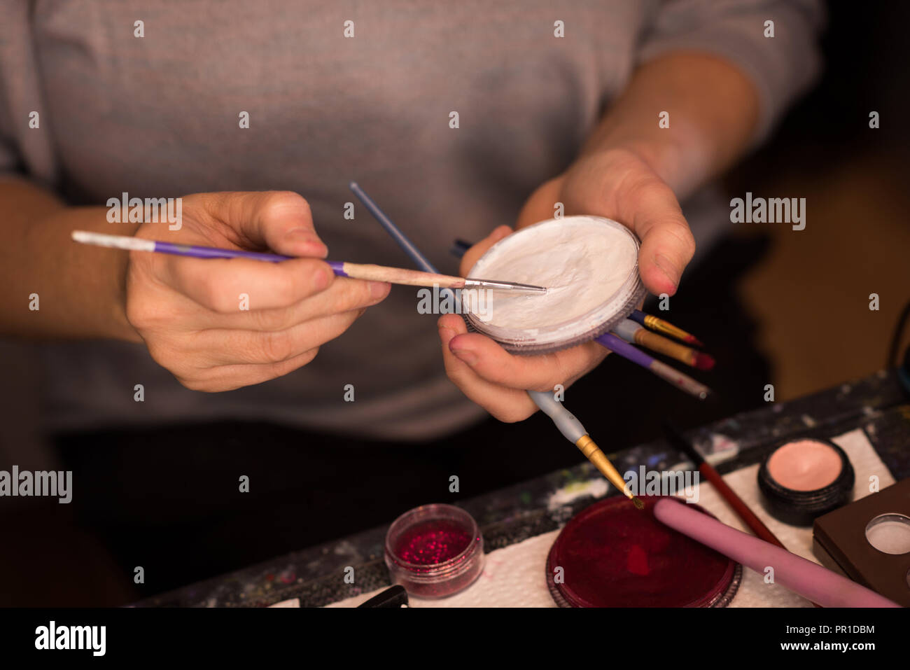 Woman painting her face with brush Stock Photo