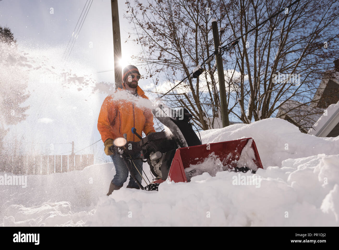 Man using snow blower machine in snowy region Stock Photo