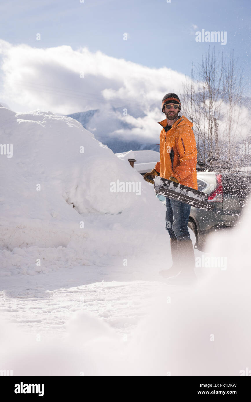 Man cleaning snow with snow shovel Stock Photo