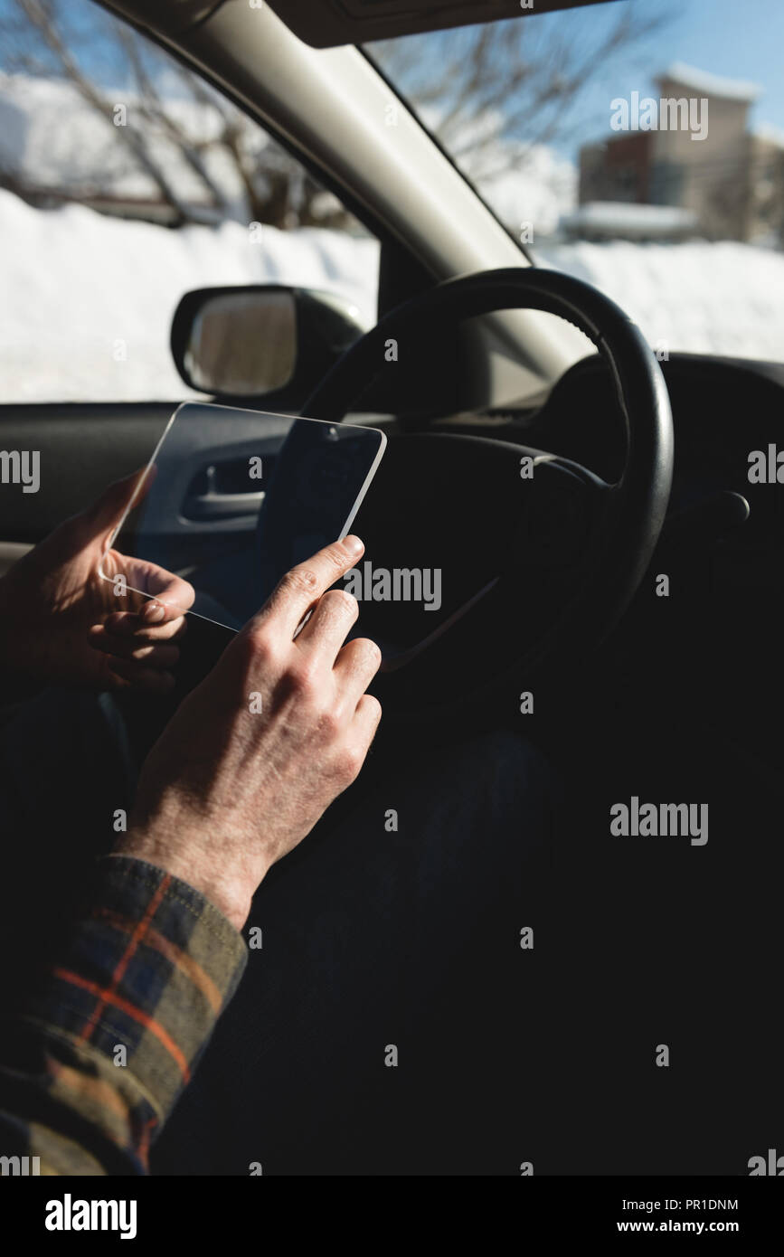Man using glass digital tablet in car Stock Photo