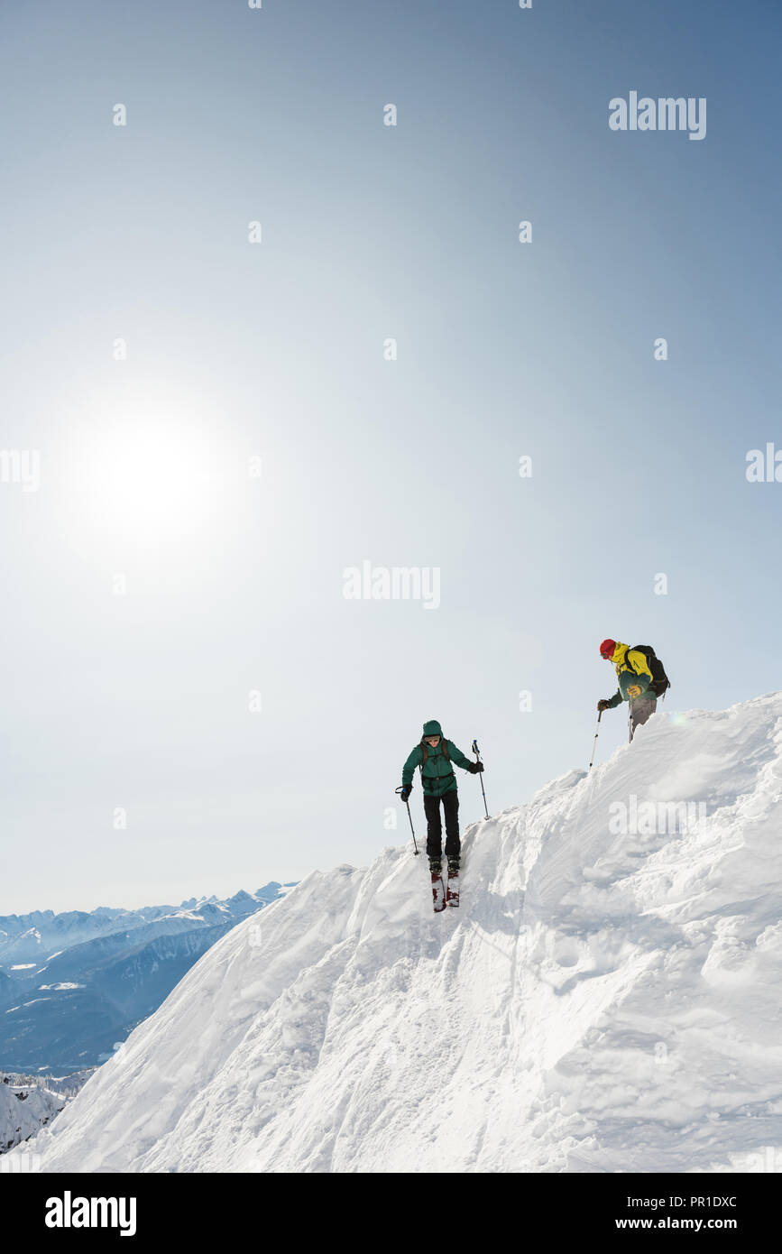 Male and female skiers skiing on a snowy mountain Stock Photo