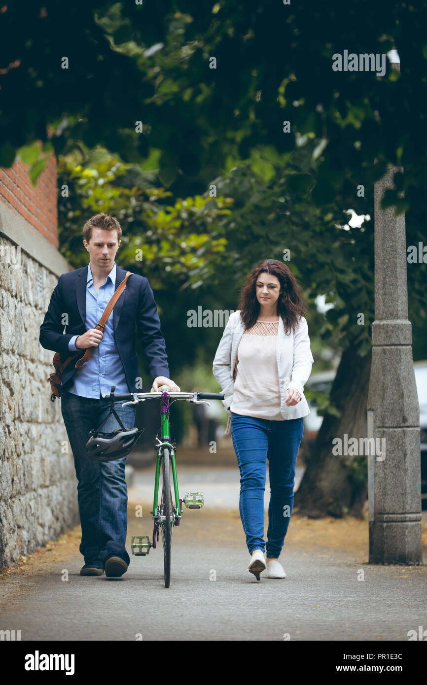 Business colleagues walking on sidewalk in city Stock Photo