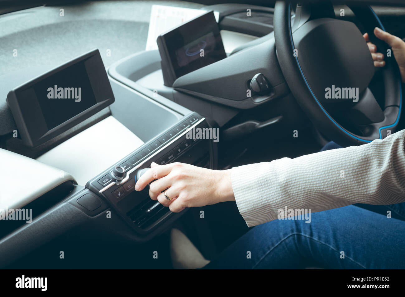 Businesswoman using music system while driving car Stock Photo